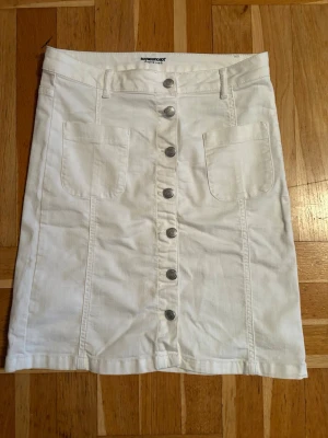 Vit kortkjol med knappar från New Look - Snygg vit kortkjol från Soyaconcept. Fickor fram. med. Knappar hela vägen. Kan inte minnas att jag ens använt den. Dock är jag expert på att klippa bort lappar direkt. Men storlek är M, passar även en S.