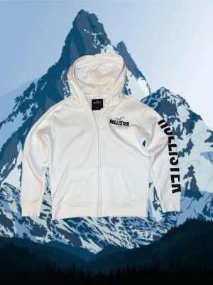 Vit Hollister hoodie S - Säljer en sjukt snygg och stilren Hollister zip hoodie i sjukt bra skick 9,5/10. Den passar som S med måtten: 65 cm lång och bred 52 cm