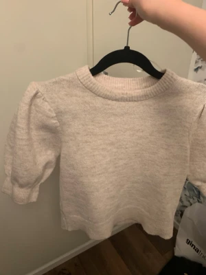 Beige stickad tröja med puffärm - Supersöt beige stickad tröja med puffärmar. Perfekt att matcha med både jeans och kjol för en snygg basic outfit!🫶🏻💕