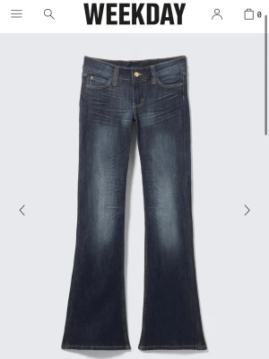 Bootcut jeans från Weekday - Mörkblå bootcut jeans från Weekday cheap monday med låg midja och klassiska fem fickor. Jeansen har snygga slitningar och kontrastsömmar, vilket ger en cool vintagekänsla. Tillverkade i denim med lätt stretch för skön passform.