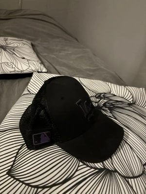 Svart LA Dodgers truckerkeps - Säljer en svart LA Dodgers truckerkeps från New Era med mesh på sidorna och bak, samt böjd skärm. SÄLJER NU en riktigt fet keps som ej kommit t användning, ny pris 300-400kr mitt pris 150kr