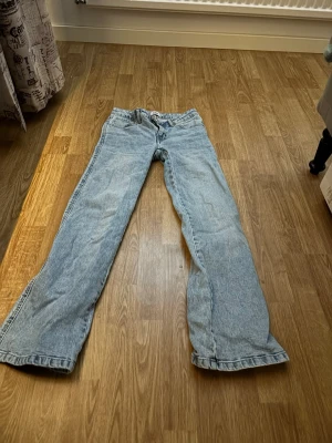 Ljusblå bootcut jeans från 157 - Säljer ett par ljusblå jeans från 157 med klassisk femficksdesign och bootcut-passform. Jeansen har normal midja och är tillverkade i denim. Perfekta för dig som gillar en avslappnad och tidlös stil.