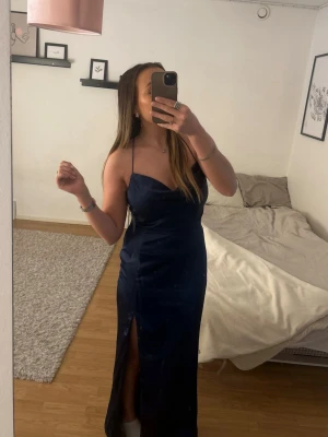 Marinblå balklänning - Nelly - Marinblå balklänning ifrån Nelly i storlek 38 (passar även för de som har strl 36). Endast använd en gång. Klänningen är i satin tyg, med korsade band i ryggen samt slits på vänster ben. (Original pris 899)