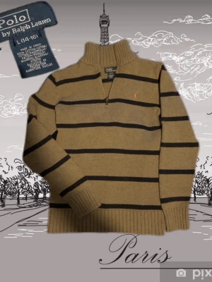 Randig stickad tröja Polo Ralph Lauren - Stickad tröja från Polo Ralph Lauren i beige med mörkblå horisontella ränder. Halv dragkedja vid halsen och ribbade muddar. Klassisk broderad logga på bröstet. Tillverkad i bomull och kashmir för extra mjuk känsla. Strl 158/164