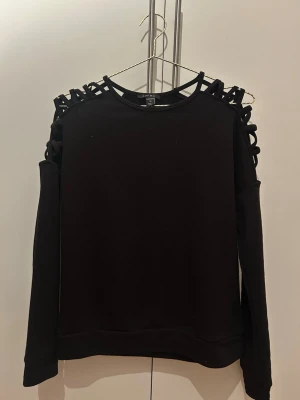 Svart tröja med coola detaljer - Säljer denna supercoola tröja från amisu. Den är i superbra skick och är knappt använd❤️ i storlek xs och utan defekter! 