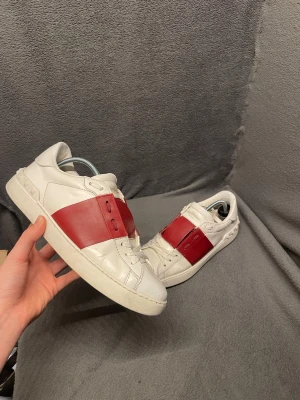 Valentino garvani open - Snygga vita valentino open med en röd detalj. Skorna är i storlek 40 men passar också 41 och nypriset ligger runt 8000. Skorna har tecken på användning. Lagning i främre skon på en av skorna vilket inte alls märks eller syns. Perfekta skor nu inför sommaren men ändå till andra årstider.                                                                    Skriv vid frågor, pris kan diskuteras🤝