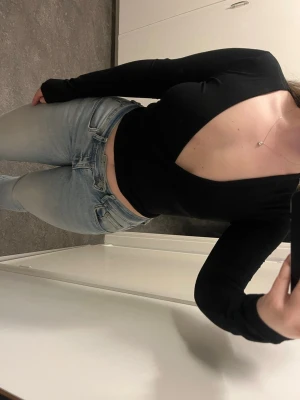 Svart långärmad wrap topp - Svart långärmad topp med djup v-ringning och knyt i midjan. 