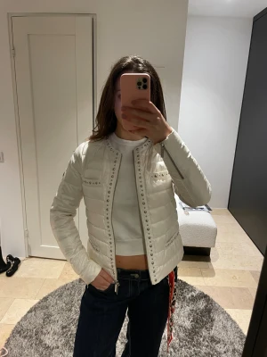 Micheal Kors Jacka cream - Jackan har inte kommit till användning och säljes därför . Den är utsmyckat med silvriga detaljer och är väldigt fin både till vardags och till festligare tillfällen. Inga defekter nypris över 1200kr 