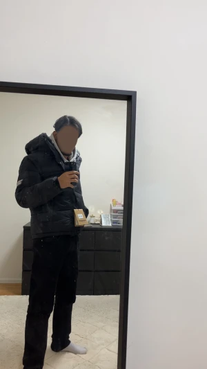 Svart dunjacka från burberry - Svart pufferjacka från Burberry med huva och rutig innerfoder i grått, vitt och rött. Jackan har två sidofickor med dragkedja och en tydlig Burberry London England patch på ärmen. Perfekt för kalla dagar och har en stilren, modern look.