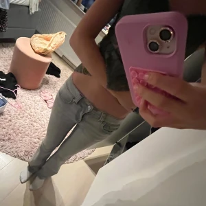 Grå bootcut jeans från Perfect Jeans - Snygga grå jeans från Perfect Jeans i storlek 36. Modellen har bootcut-ben och låg midja, med coola fickor bak som har lock och knappdetaljer.