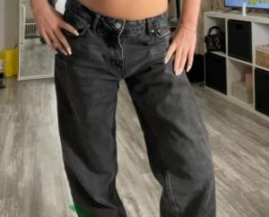 Svarta baggy jeans från Gina tricot - Säljer ett par svarta jeans från Levi's med bred passform och klassisk femficksdesign. Jeansen har en avslappnad, loose fit och baggy. Perfekta för dig som gillar en trendig och bekväm stil.