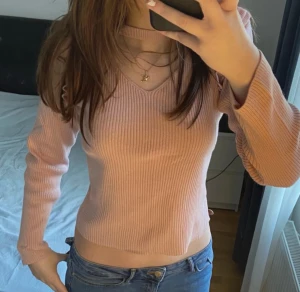 Rosa ribbad stickad tröja med v-ringning - Säljer en ljusrosa stickad tröja från Kappahl med ribbad struktur och v-ringad hals. Tröjan har långa ärmar och sitter snyggt figurnära utan att vara för tight. Perfekt att matcha med jeans för en chill look. Eftersom tröjan är i barnstorlek skulle säga att den sitter som en S i vanliga fall. 