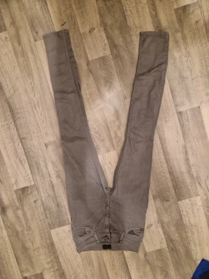 Grå jeans med raka ben - Pris kan diskuteras Snygga grå jeans med klassisk femficksdesign och raka ben. Jeansen har en neutral grå färg och är tillverkade i ett mjukt bomullsmaterial med lite stretch. Passar dig som gillar enkel och stilren look. Svart patch bak i midjan.