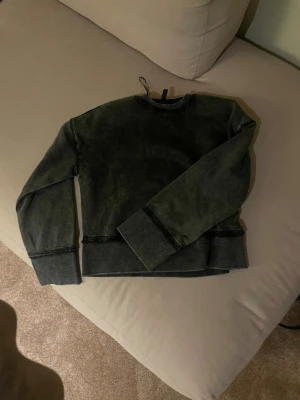 Mörkgrå sweatshirt i XXS - En mörkgrå sweatshirt i croppad modell med breda muddar och rund hals. Tröjan har en avslappnad passform och är tillverkad i mjuk bomullsmix, perfekt för chill dagar. Enkel och stilren design som funkar till det mesta.