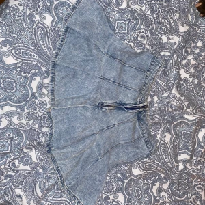 Lowwaist jeans kjol - Supersöt ljusblå jeanskjol från FB Sister i storlek S. Kjolen har en kort, utsvängd modell med markerade sömmar och dragkedja framtill. Perfekt för dig som gillar en chill och trendig denimlook.