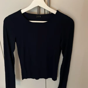  långärmad topp - En stilren marinblå långärmad topp med rund halsringning. Modellen är enkel och tight, perfekt att matcha med jeans eller kjol. Tunn och mjuk i materialet, vilket gör den skön att bära. Passar dig som gillar minimalistisk och clean stil. 