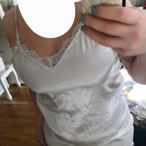 Vit satin pyjamas sett - En söt vit pyjamas sett i satin med tunna axelband och v-ringning. Både linnet o shortsen har spets detaljer som ni kan se. axelbanden på linnet går att justera där bak, shortsen är inte använda endast använt linnet den är fin att använda som ”vanlig” oxå.💕✨(inte mycket stretch i)