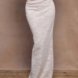 Vit spetskjol från Aesum - Supersnygg långkjol från Aesum i vit spets med blommigt mönster. Kjolen är figurnära och har en elegant, rak passform. Perfekt för dig som vill ha en romantisk och trendig look. Materialet är polyester med vacker spetsdetalj. Säljer pga aldrig använt därav prislapp kvar 