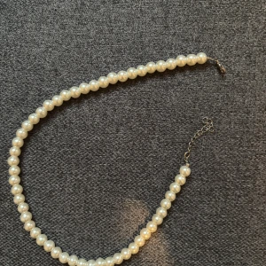 Pärlhalsband med justerbar kedja - Snyggt halsband med vita pärlor och en justerbar kedja i silverfärg. Perfekt accessoar för att lyfta vilken outfit som helst. Klassisk design med rundade pärlor som ger en tidlös känsla.