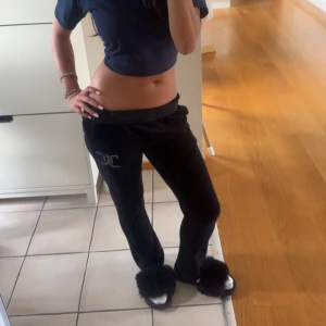 Svarta mjukisbyxor med strassdetalj - Svarta tajta byxor från Juicy Couture. De har hög midja men du kan vika ner dem som jag har gjort på några av bilderna. Storleken motsvarar ålder 14/15 år < dom passar mig och jag brukar använda (S) i byxor