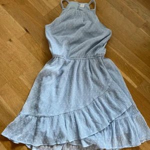 Ljusblå klänning med volang  - Superfin ljusblå klänning från Lindex med tunna axelband och volangdetaljer. 