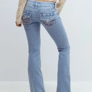 Ljusblå bootcut jeans med broderad ficka - Säljer ett par ljusblå jeans med bootcut passform och snygga broderade bakfickor. Helt nya med prislapp kvar, hör av er för fler bilder🥰 storlek M från ginas 14+ kollektion 