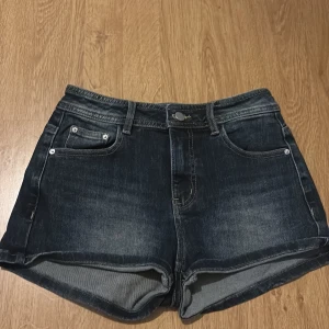 Mörkblå jeansshorts med fickor - Snygga mörkblå jeansshorts från IEF i klassisk femficksmodell. Shortsen har uppvikta benslut, bälteshällor och bakfickor med lock och knapp. Perfekta för sommardagar och ger en cool, avslappnad vibe.