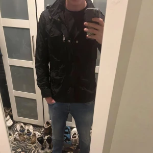 Polo Ralph lauren field jacket - Snygg svart jacka från Polo Ralph Lauren med dragkedja och knappar. Jackan har flera praktiska fickor och en stilren design. Perfekt för en cool och avslappnad look. Nypris runt 5000kr! Äkthetsbevis finns! Bara höra av sig vid eventuella funderingar!