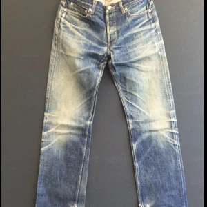 Nudie Jeans Grim Tim Dry Japan Selvage - Säljer ett par Nudie Jeans Grim Tim Dry Japan Selvage i mörkblå denim med klassiska orange sömmar och signaturbroderi på bakfickorna. Modellen har rak passform och är tillverkad i 98% bomull och 2% elastan för extra stretch. Riktigt snygga jeans med premiumkänsla. På sista bilden kan man se hur dessa kommer utvecklas och se ut vid längre användning. Tjecks inte på att höra av dig minsta fråga. Pris kan diskuteras vid snabb affär.