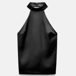 Svart halterneck topp med rosett Zara - Snygg svart halterneck topp från Zara i satinliknande material. Toppen har hög krage med knäppning i nacken och en stor dekorativ rosett bak. 