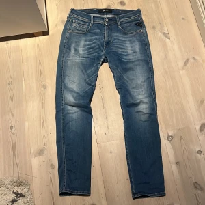 Blå Replay Anbass  - Slimmade blå jeans från Replay i modellen Anbass. Tillverkade i mjukt denimtyg med lätt slitningar och kontrastsömmar. Perfekta för dig som gillar en stilren och avslappnad look. 29 waist 30 length. Kol gärna med prisförslag!!!