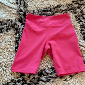 Roda gymshorts med mid rise  - Snygga rosa gym shorts med mid rise. Bra skick och har inte använts jätte mycket. Bra för idrott. Storlek: xxs