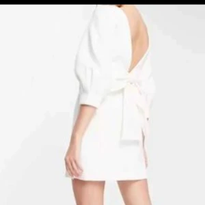 Forever new Vit kort klänning med rosett i ryggen 38, uk 10 - Superfin vit kort klänning med puffärmar och stor rosett i ryggen. Djup v-ringad rygg ger en snygg och unik look. Klänningen har en stilren design och är tillverkad i ett slätt tyg som känns lyxigt. Perfekt för dig som vill sticka ut med en elegant och trendig stil. Kemtvättat. Använt en gång. Istl uk 10, eu 38. Köptes från asos och blev slutsåld på direkten. Ny pris 1400 kr.