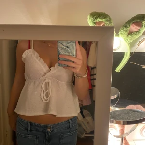 Vit omlott linnetopp med volang - Supersöt vit omlott linnetopp med volangkant och knyt framtill. Perfekt fest eller middags topp💕💕