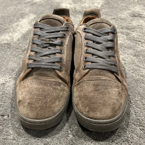 Gråa loubs - Gråa loubs med klassiska röda sulor. Skorna har rund tå, gråa snören och diskret branding på sulan. Dem är använda så de kanske är någon storlek större än originalstorlek som är 40. Sitter som 41. Pris kan diskuteras och tar emot byten