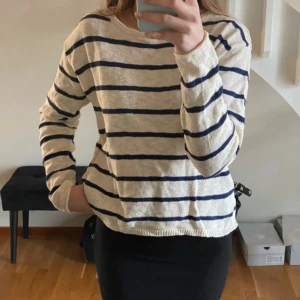 Randig beige och marinblå tröja - Säljer min crémevita finstickade tröja med blå ränder. Fin slit i sidan🥰strl 170 och passar mig som har xs