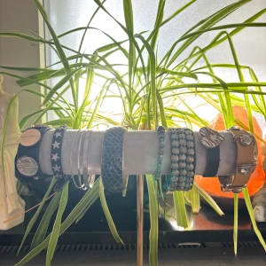 Mix av armband i olika stilar - Säljer flera armband: ett svart läderarmband med silverfärgad dödskalle och nitar, ett smalt svart läderarmband med silvriga skruvdetaljer samt ett strandigt fot accessoar med vita snäckor och turkos stjärndetalj. Perfekt för dig som gillar att mixa edgy och boho.      pris går att diskutera men riktar mig åt 10-20 kr styck    
