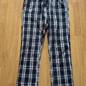 Rutiga pyjamasbyxor  - Pyjamasbyxor i blått och vitt rutigt mönster. De har resår i midjan och snörning för extra komfort. Fint skick. 