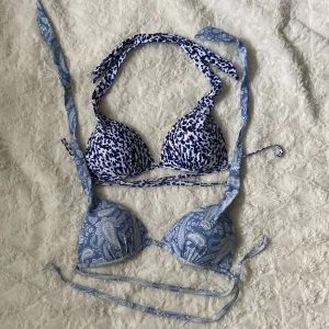 Blå och vit bikini med mixade mönster - Säljer en unik bikini med trekantsmodell och knytband. Ena kupan är blå med vitt paisleymönster, andra kupan är vit med blått leopardmönster. Båda kuporna har matchande knytband. Perfekt för dig som vill sticka ut på stranden! 30kr/st