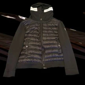 Svart Moncler cardigan - Säljer en svart Moncler cardigan med luva i mycket fint skick. Äkta vara med exklusiv känsla – en perfekt kombination av street och lyx. Passar lika bra till vardags som till en snyggare outfit.  🧥 Detaljer: • Färg: Svart • Storlek: M (liten i storleken) • Med huva • Mjukt tyg med stickade ärmar eller detaljer (modellberoende) • Klassisk Moncler-logga på ärmen • Dragkedja fram  ✅ Väldigt lite använd och i toppskick – inga fläckar, hål elle