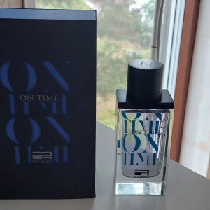 Rue Broca On Time parfym - Ny endast testad. Rue Broca On Time är en stilren parfym i en genomskinlig glasflaska med svart fyrkantigt lock. Flaskan har blå och vita detaljer med modern textdesign. Kommer i en snygg svart kartong med blå text. Perfekt för dig som gillar minimalistisk och trendig design.