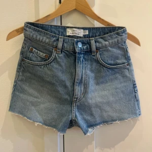 Blå jeansshorts & Other Stories - Blå jeansshorts från & Other Stories som är tillverkade i bara bomull. Perfekta för sommaren med en avslappnad och tidlös vibe. Snyggt ljusblå tvätt och fransig benkant. Aldrig använda i storlek 34 💕