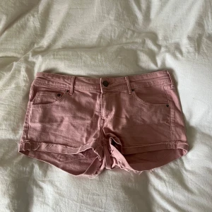 Rosa jeansshorts från H&M Conscious - Snygga ljusrosa lågmidjade jeansshorts från H&M Conscious Collection. Modellen har normal passform, klassiska fem fickor och råa kanter nertill . passar dig som använder storlek 38 . också köpa på Plick , men har tyvärr inte använt eftersom att jag inte kan styla dem rätt