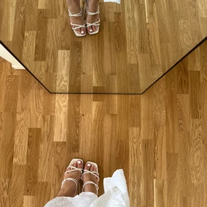 Vita sandaler med klack och remmar - Snygga vita sandaler med smala remmar och fyrkantig tå. Skorna har en låg klack och öppen tå, vilket ger en trendig och fräsch look. Perfekta till sommarens outfits och lätta att matcha med både klänning och jeans.