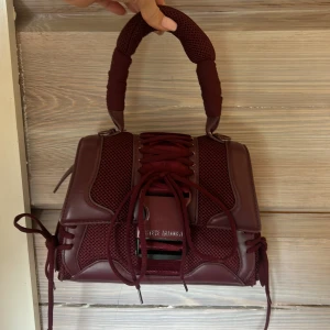 Steve Madden handväska - Steve Madden Bdiego vinröd liten handväska❣️ Köpt i januari 24. Använd få gånger, därför säljer jag 💘. Axelrem kommer med. Skriv om du vill ha fler bilder eller något!