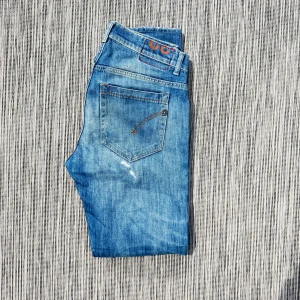 Dondup jeans - Snygga blå jeans med klassisk femficksdesign och en cool orange detalj på bakfickan. Jeansen har en tvättad look och raka ben. Perfekta för en avslappnad stil.!AI BESKRIVNING! Om ni vill ha fler bilder eller undrar något så skriv.