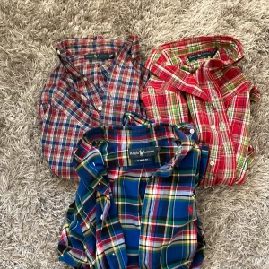 3 rutiga skjortor från Ralph Lauren M 3st för 750kr - Tre klassiska rutiga skjortor från Ralph Lauren i storlek M. Skjortorna har färger i rött, blått, grönt och gult och är tillverkade i mjuk bomull. Alla har knappar framtill och klassisk krage. 