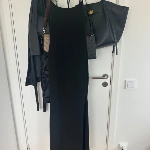 Svart långklänning med smala axelband - En stilren svart långklänning med smala axelband. Klänningen är från SHEIN och aldrig använd.