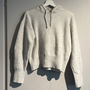 Stickad hoodie - Säljer en ljusgrå stickad hoodie från Gina Young i storlek 158/164. Använd fåtal gånger, tröjan har blivit nopprig efter tvätten men annars inga defekter. Säljer en likadan fast i mörkblå i annan annons. Köparen betalar frakten!