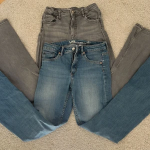 2 par LAB Industries jeans, grå & blå - Två par jeans från LAB Industries i storlek 164. Ena paret är klassiskt blå med lätt tvättad look, det andra är grått. Båda har fem fickor, normal passform och är tillverkade i stretchig denim av 99% bomull och 1% elastan. Perfekta för en avslappnad stil.